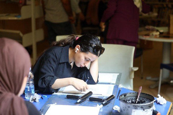 فنانون فلسطينيون خلال ورشة «الزمان والمكان» في مدينة غزة، حيث جسدت أعمالهم واقع الحرب والنزوح ورسائل الأمل والصمود، 15 أغسطس/آب 2026. تصوير: بلال أسامة.