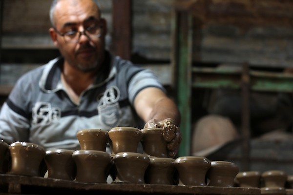 عمال فلسطينيون يصنعون الفخار يدويًا داخل مصنع متضرر في منطقة النفاق بمدينة غزة، في 6 أغسطس/آب 2026، محافظين على حرفة توارثوها عبر الأجيال رغم الدمار ونقص الموارد والمعدات. تصوير: بلال أسامة