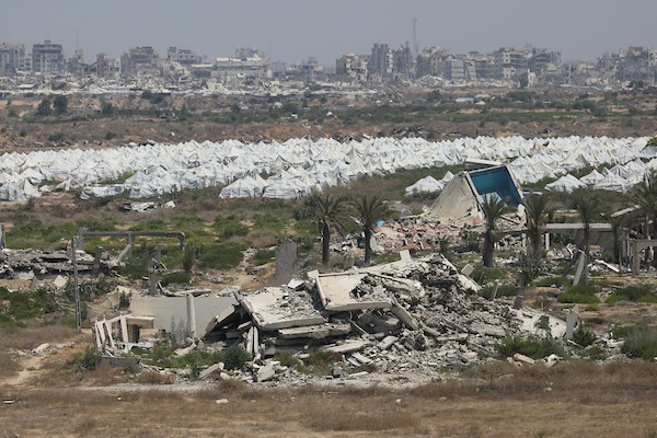 فلسطينيون يتنقلون بين أنقاض مبانٍ مدمرة في منطقة المغاري وسط قطاع غزة، في مشهد يعكس حجم الأضرار التي لحقت بالمناطق السكنية خلال الحرب. (تصوير: حسن الجدي)