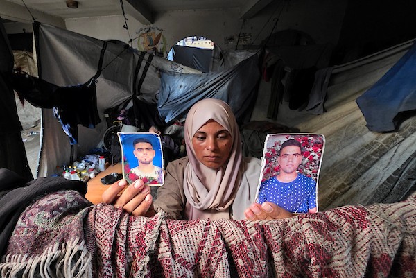 الفلسطينية فاطمة النجار تحمل صورة شقيقها محمد داخل خيمة للنازحين في خان يونس، جنوب قطاع غزة، في 30 أغسطس/آب 2026، بينما تواصل انتظار أي خبر عن مصيره في اليوم الدولي للمفقودين. تصوير: طارق محمد