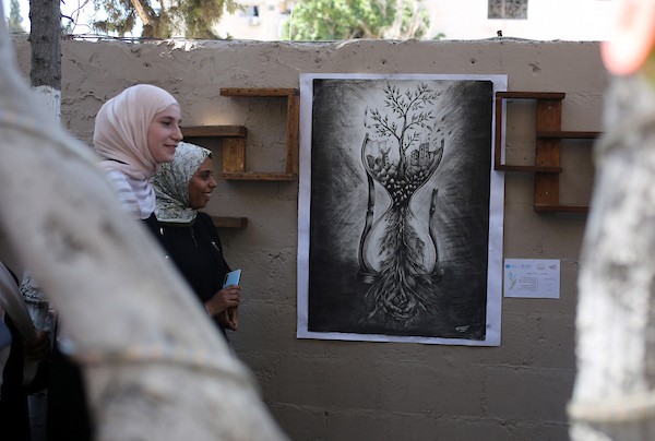 حضر فلسطينيون معرض ريشة السلام الذي ضمّ أعمالاً فنية ورسومات لشابات من مدينة غزة، وذلك في 30 أغسطس/آب 2026. تصوير: محمد صالحة