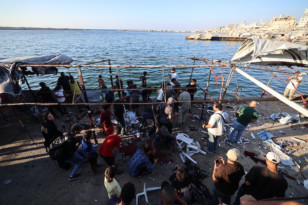 فلسطينيون في موقع غارة جوية إسرائيلية استهدفت مجموعة من المدنيين على الواجهة البحرية غرب مدينة غزة، في 18 أغسطس/آب 2026.(صورة: هادي داود)