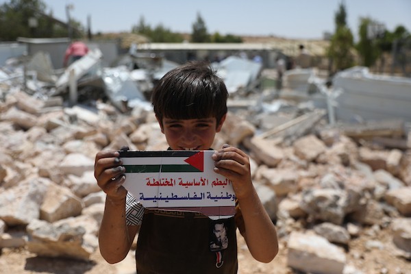 فلسطينيون يتفقدون أنقاض الجزء المهدوم من مدرسة شعب البطم الأساسية المختلطة جنوب الخليل، في مشهد يجسد التحديات التي تواجه حق الأطفال في التعليم. (تصوير: مأمون وزواز)