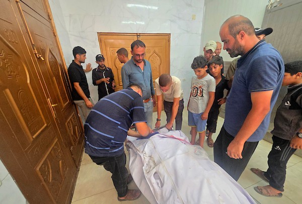 نقل مسعفون فلسطينيون جثمان عزام رفعت العبادلة إلى مجمع ناصر الطبي بعد استشهاده إثر قصف طائرة إسرائيلية لخيمة في منطقة المواصي بخان يونس، جنوب قطاع غزة، في 27 أغسطس/آب 2026. (صورة: طارق محمد)