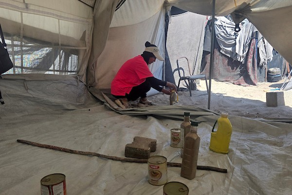 مدربة اللياقة البدنية إيمان المغير تستخدم علب طعام فارغة ومواد مهملة كأدوات رياضية خلال تدريبها داخل خيمتها في خان يونس.تصوير: طارق محمد