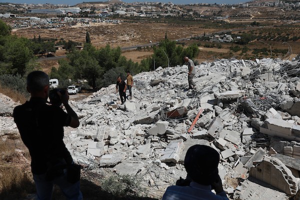 يتفقد فلسطينيون أنقاض منزل قيد الإنشاء هدمته القوات الإسرائيلية في قرية كرمة، جنوب مدينة دورا بالضفة، في 27 أغسطس/آب 2026.(صورة: مأمون وزواز)
