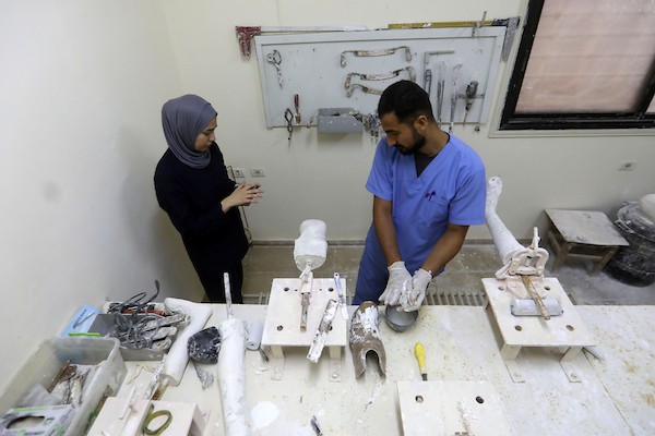 أخصائيون فلسطينيون يصنعون ويجهزون أطرافًا اصطناعية لجرحى الحرب ومبتوري الأطراف في مركز تديره بلدية غزة بمدينة غزة، في 11 أغسطس/آب 2026. (صورة: بلال أسامة)
