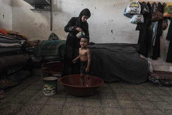 فلسطينيون نازحون داخل ملاجئ تابعة لـ«الأونروا» في مخيم النصيرات، وسط قطاع غزة، في 7 أغسطس/آب 2026، في ظل ارتفاع درجات الحرارة ونقص التهوية والكهرباء والمياه. تصوير: معز صالحي