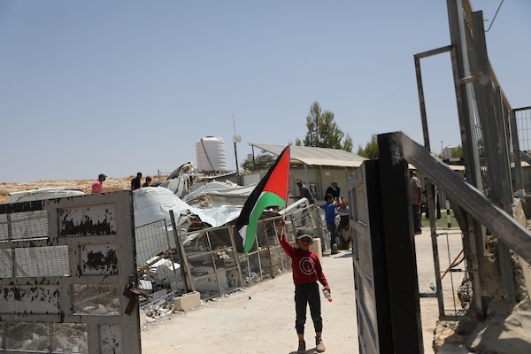 فلسطينيون يتفقدون أنقاض الجزء المهدوم من مدرسة شعب البطم الأساسية المختلطة جنوب الخليل، في مشهد يجسد التحديات التي تواجه حق الأطفال في التعليم. (تصوير: مأمون وزواز)