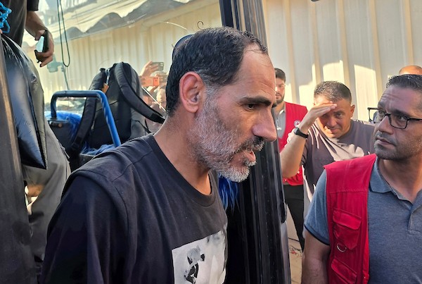 أسرى ومعتقلون فلسطينيون مفرج عنهم يصلون على متن حافلات تابعة للجنة الدولية للصليب الأحمر إلى مجمع ناصر الطبي في خان يونس، جنوب قطاع غزة، بعد نقلهم من معبر كرم أبو سالم، وسط تجمع أفراد من عائلاتهم لاستقبالهم.(تصوير: طارق محمد)