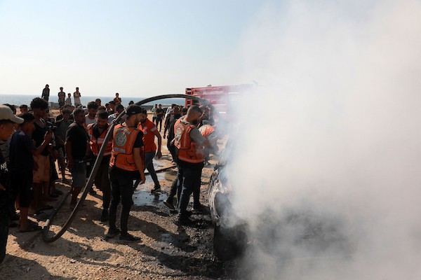 عناصر من الدفاع المدني وفلسطينيون نازحون يعملون على إخماد حريق اندلع في سيارة عقب غارة إسرائيلية على شارع الرشيد، جنوب غرب مدينة غزة، قطاع غزة، في 13 أغسطس/آب 2026.صورة: أحمد إبراهيم