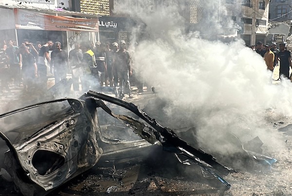 تجمّع فلسطينيون في موقع غارة إسرائيلية استهدفت مركبة مدنية في حي تل الهوى بمدينة غزة في 31 أغسطس/آب 2026، بينما يحاول رجال الإطفاء إخماد حريق اندلع في الموقع. وانتشلت فرق الإسعاف جثث ثلاثة فلسطينيين استشهدوا في الغارة. (صورة: هادي داود)