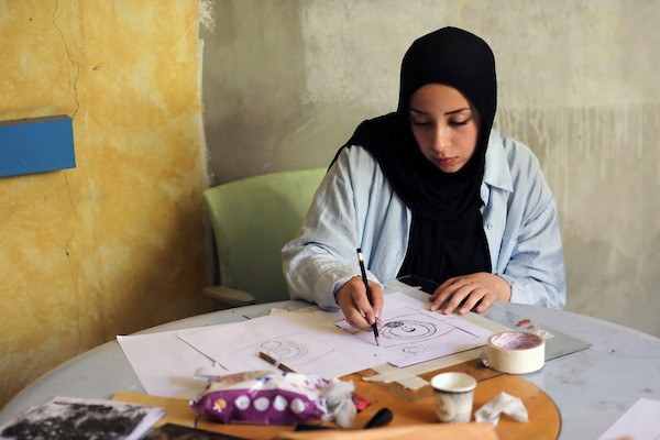 فنانون فلسطينيون خلال ورشة «الزمان والمكان» في مدينة غزة، حيث جسدت أعمالهم واقع الحرب والنزوح ورسائل الأمل والصمود، 15 أغسطس/آب 2026. تصوير: بلال أسامة.