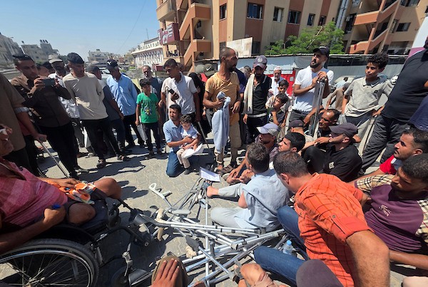 مرضى وجرحى فلسطينيون يحملون تحويلات طبية في احتجاج أمام مجمع ناصر الطبي في خان يونس، جنوب قطاع غزة، في 23 أغسطس/آب 2026، (صورة: طارق محمد)