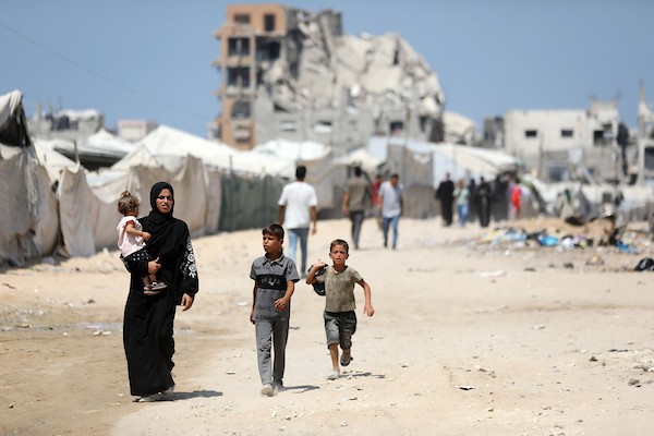 فلسطينيون نازحون يمارسون تفاصيل حياتهم اليومية بين خيام الإيواء والمباني المدمرة في شمال مدينة غزة، في 27 آب/أغسطس 2026. (تصوير: بلال أسامة)
