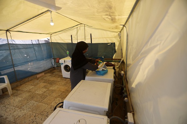 فلسطينيون يغسلون ملابسهم باستخدام غسالات كهربائية داخل مخيم للنازحين غرب مدينة غزة، في 27 أغسطس/آب 2026، وسط صعوبات في تأمين المياه والكهرباء. (تصوير: بلال أسامة)