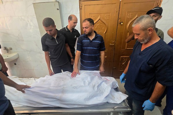 نقل مسعفون فلسطينيون جثمان عزام رفعت العبادلة إلى مجمع ناصر الطبي بعد استشهاده إثر قصف طائرة إسرائيلية لخيمة في منطقة المواصي بخان يونس، جنوب قطاع غزة، في 27 أغسطس/آب 2026. (صورة: طارق محمد)