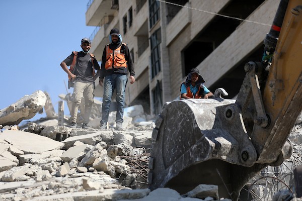 عناصر من الدفاع المدني الفلسطيني، بالتعاون مع اللجنة الدولية للصليب الأحمر، يعملون بإمكانيات محدودة لانتشال جثث من تحت أنقاض منزل عائلة غربية غرب مدينة غزة، في 11 أغسطس/آب 2026. (صورة: بلال أسامة)