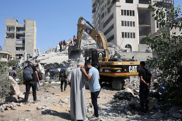 عناصر من الدفاع المدني الفلسطيني، بالتعاون مع اللجنة الدولية للصليب الأحمر، يعملون بإمكانيات محدودة لانتشال جثث من تحت أنقاض منزل عائلة غربية غرب مدينة غزة، في 11 أغسطس/آب 2026. (صورة: بلال أسامة)