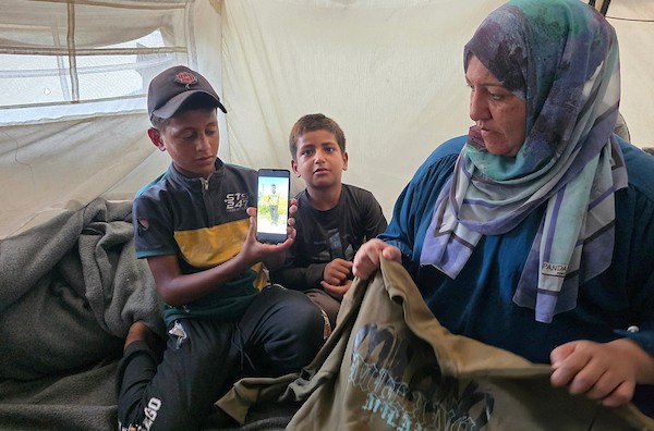 الفلسطينية سمية الرقب تحتضن صورة وملابس ابنها أحمد داخل خيمة للنازحين في خان يونس، جنوب قطاع غزة، في 30 أغسطس/آب 2026، بينما تواصل انتظار أي خبر عن مصيره في اليوم الدولي للمفقودين.