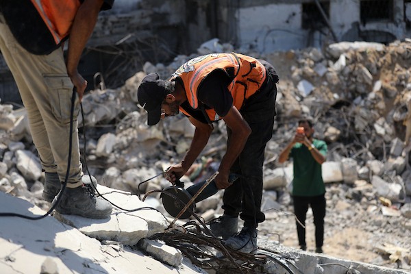 عناصر من الدفاع المدني الفلسطيني، بالتعاون مع اللجنة الدولية للصليب الأحمر، يعملون بإمكانيات محدودة لانتشال جثث من تحت أنقاض منزل عائلة غربية غرب مدينة غزة، في 11 أغسطس/آب 2026. (صورة: بلال أسامة)