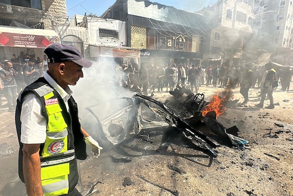 تجمّع فلسطينيون في موقع غارة إسرائيلية استهدفت مركبة مدنية في حي تل الهوى بمدينة غزة في 31 أغسطس/آب 2026، بينما يحاول رجال الإطفاء إخماد حريق اندلع في الموقع. وانتشلت فرق الإسعاف جثث ثلاثة فلسطينيين استشهدوا في الغارة. (صورة: هادي داود)