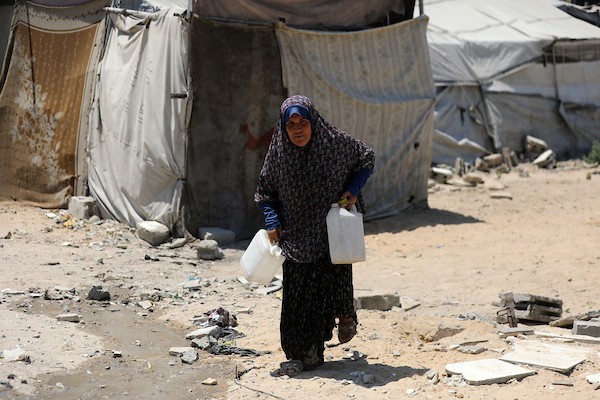 أطفال فلسطينيون نازحون يرتشفون الماء قرب مخيمات النزوح بجوار حي الشجاعية، شرق مدينة غزة، في 9 أغسطس/آب 2026، وسط ارتفاع درجات الحرارة وظروف معيشية صعبة في الخيام ومحدودية وسائل التبريد والخدمات الأساسية. (تصوير: بلال أسامة)