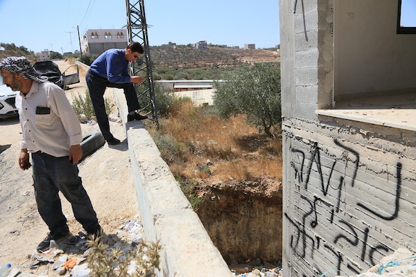 فلسطينيون يعاينون سيارات محترقة عقب هجوم لمستوطنين إسرائيليين استهدف منازل وممتلكات وخطوط كهرباء بين قريتي جالود وتلفيت، قرب نابلس، في 4 أغسطس/آب 2026. (تصوير: محمد ناصر)