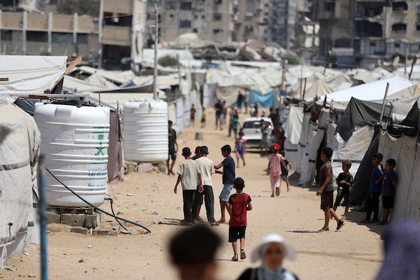 فلسطينيون نازحون يمارسون تفاصيل حياتهم اليومية بين خيام الإيواء والمباني المدمرة في شمال مدينة غزة، في 27 آب/أغسطس 2026. (تصوير: بلال أسامة)