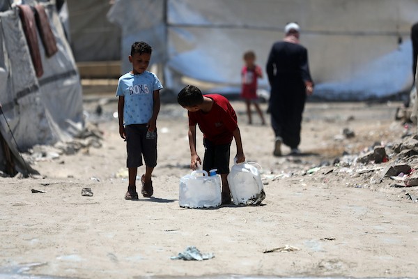فلسطينيون نازحون يتجمعون للحصول على المياه في مخيم على شاطئ مدينة غزة، في 12 أغسطس/آب 2026. (صورة: أسامة)