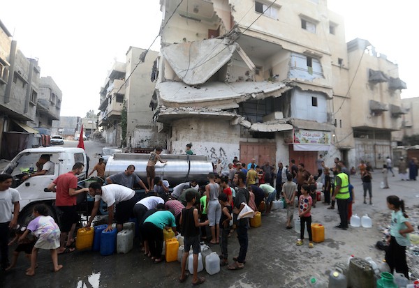 نازحون فلسطينيون ينتظرون الحصول على المياه قرب