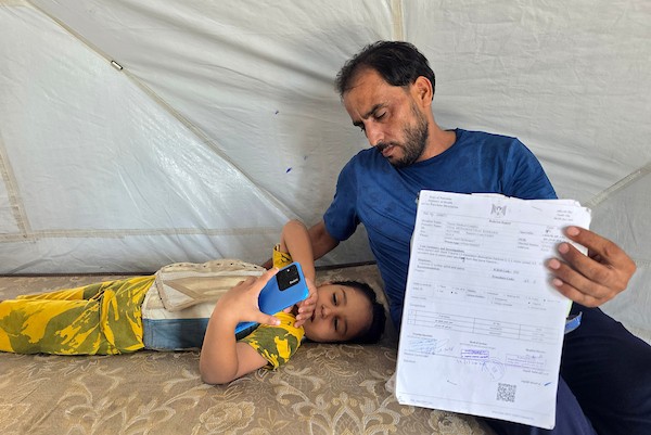 الطفل فيصل بربخ داخل خيمة عائلته في خان يونس، جنوب قطاع غزة، في 6 أغسطس/آب 2026، بانتظار السفر لتلقي العلاج بعد إصابته بكسور في العمود الفقري إثر انهيار جدار أودى بحياة شقيقته إيلاف.تصوير: طارق محمد