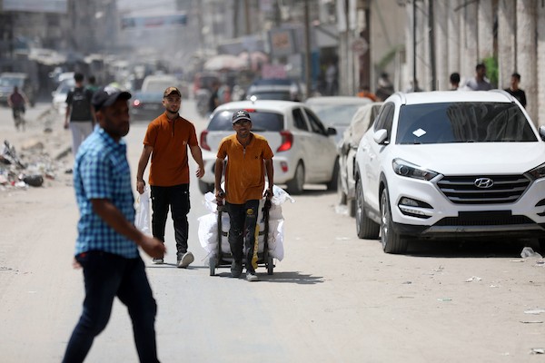 فلسطينيون نازحون يمارسون تفاصيل حياتهم اليومية بين خيام الإيواء والمباني المدمرة في شمال مدينة غزة، في 27 آب/أغسطس 2026. (تصوير: بلال أسامة)