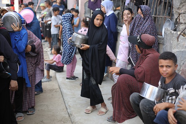 نازحون يحملون أواني الطعام والحاويات أثناء انتظارهم الحصول على وجبات من مطبخ خيري في شمال قطاع غزة، في 29 أغسطس/آب 2026. (تصوير: حسن الجدي)