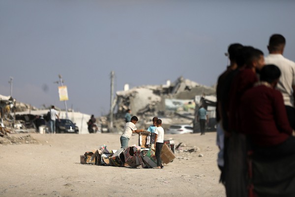 فلسطينيون يسيرون بين أنقاض المباني المدمرة في مخيم جباليا شمال قطاع غزة. تصوير: بلال أسامة