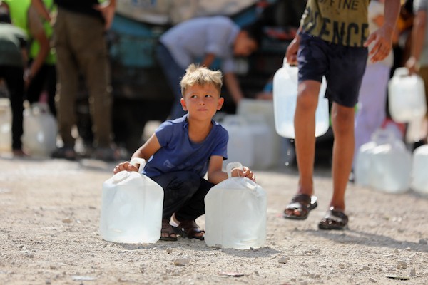 نازحون فلسطينيون ينتظرون الحصول على المياه قرب