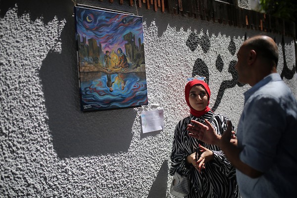 حضر فلسطينيون معرض ريشة السلام الذي ضمّ أعمالاً فنية ورسومات لشابات من مدينة غزة، وذلك في 30 أغسطس/آب 2026. تصوير: محمد صالحة