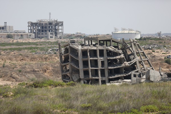 فلسطينيون يتنقلون بين أنقاض مبانٍ مدمرة في منطقة المغاري وسط قطاع غزة، في مشهد يعكس حجم الأضرار التي لحقت بالمناطق السكنية خلال الحرب. (تصوير: حسن الجدي)