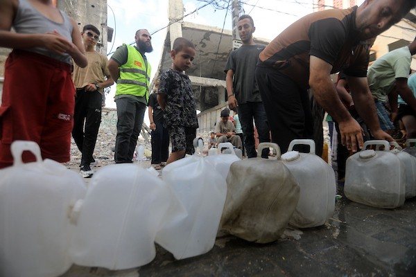 نازحون فلسطينيون ينتظرون الحصول على المياه قرب