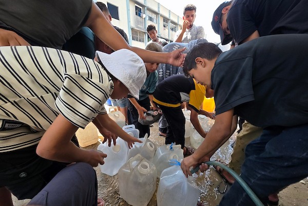 فلسطينيون، بينهم نساء وأطفال، يملؤون حاويات بمياه محلاة في محطة تحلية مياه بخان يونس، جنوب قطاع غزة، في 23 أغسطس/آب 2026.(صورة: طارق محمد)