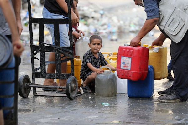 نازحون فلسطينيون ينتظرون الحصول على المياه قرب