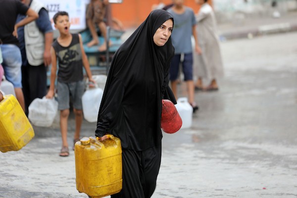 نازحون فلسطينيون ينتظرون الحصول على المياه قرب