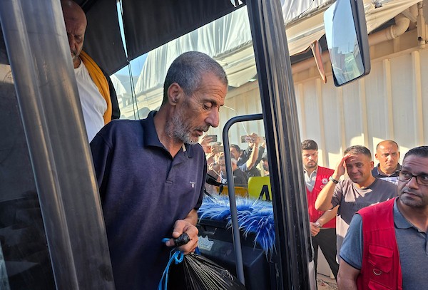 أسرى ومعتقلون فلسطينيون مفرج عنهم يصلون على متن حافلات تابعة للجنة الدولية للصليب الأحمر إلى مجمع ناصر الطبي في خان يونس، جنوب قطاع غزة، بعد نقلهم من معبر كرم أبو سالم، وسط تجمع أفراد من عائلاتهم لاستقبالهم.(تصوير: طارق محمد)