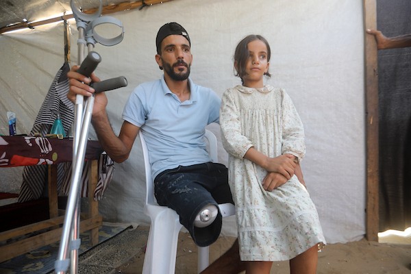 الحلاق الفلسطيني شادي البراوي، 35 عاما، يعمل داخل خيمة نزح إليها مع عائلته في مدينة غزة، في 27 آب/أغسطس 2026، بعدما فقد ساقه اليمنى إثر إصابته بشظايا خلال هجوم إسرائيلي.(تصوير: بلال أسامة)