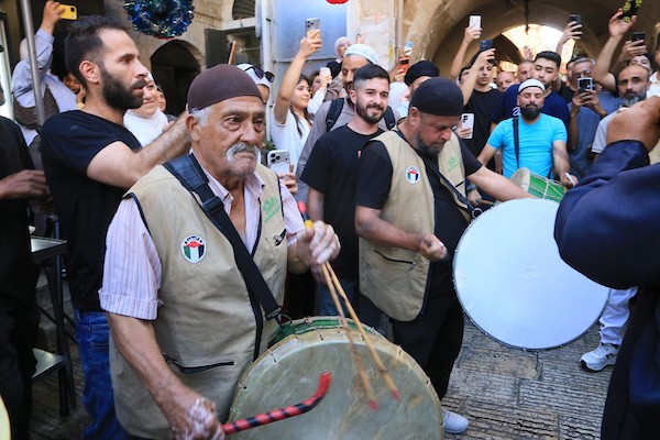 فلسطينيون بالزي التقليدي يؤدون أناشيد ومدائح دينية ويوزعون الحلوى في السوق المركزي بالبلدة القديمة في نابلس،خلال إحياء ذكرى المولد النبوي الشريف، في 25 أغسطس/آب 2026. (تصوير: محمد ناصر)