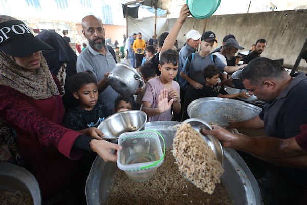 نازحون فلسطينيون يتجمعون لتلقي وجبات طعام من مطبخ خيري في مخيم النصيرات للاجئين، وسط قطاع غزة، في 16 آب/أغسطس 2026. (صورة: حسن الجدي)