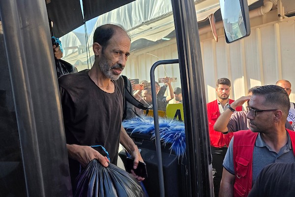 أسرى ومعتقلون فلسطينيون مفرج عنهم يصلون على متن حافلات تابعة للجنة الدولية للصليب الأحمر إلى مجمع ناصر الطبي في خان يونس، جنوب قطاع غزة، بعد نقلهم من معبر كرم أبو سالم، وسط تجمع أفراد من عائلاتهم لاستقبالهم.(تصوير: طارق محمد)