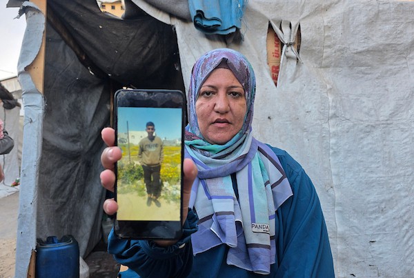 الفلسطينية سمية الرقب تحتضن صورة وملابس ابنها أحمد داخل خيمة للنازحين في خان يونس، جنوب قطاع غزة، في 30 أغسطس/آب 2026، بينما تواصل انتظار أي خبر عن مصيره في اليوم الدولي للمفقودين.