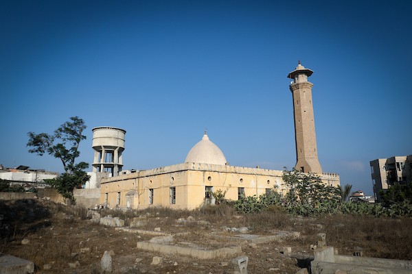 متطوعون من فريق حماة التراث يعملون على ترميم مسجد أبو سليم التاريخي في دير البلح وسط قطاع غزة، في 27 آب/أغسطس 2026. (تصوير: معز صالحي)