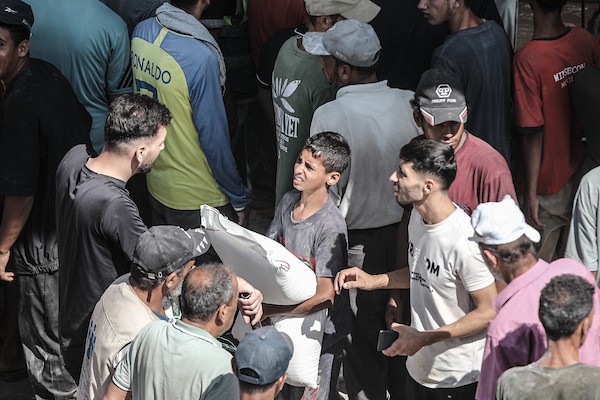 فلسطينيون يتلقون مساعدات غذائية من برنامج الأغذية العالمي في مخيم النصيرات وسط قطاع غزة، في 19 أغسطس/آب 2026، بالتزامن مع اليوم العالمي للعمل الإنساني. الصورة: معز صالحي